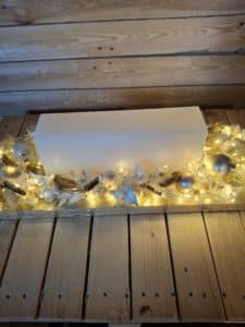 Adventsarrangement Gold mit cremefarbener Blockkerze und goldener Weihnachtsdekoration