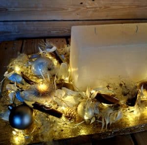 Detailaufnahme Adventsarrangement Gold mit Lichterkette und Naturmaterialien