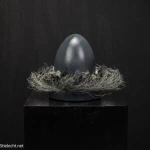 Osterdekoration mit Keramik-Ei auf verzinktem Drahtteller